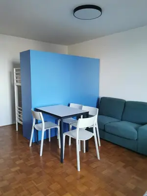 a dining room with a table and chairs and a couch at Dunajska Apartment in Ljubljana