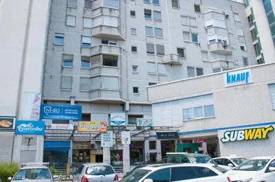 a large building with cars parked in front of it at Dunajska Apartment in Ljubljana