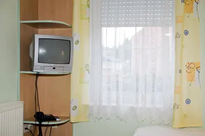 a television sitting on a shelf next to a window at Guest house Bohorč in Šentjur
