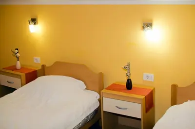 a bedroom with two beds and two lights on the wall at Guest house Bohorč in Šentjur