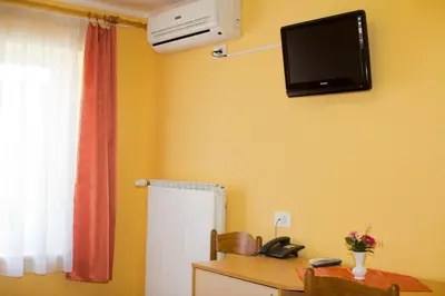 a room with a desk and a television on the wall at Guest house Bohorč in Šentjur