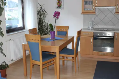 a kitchen with a wooden table with chairs and a table and a table at Apartma Maržič in Kranjska Gora