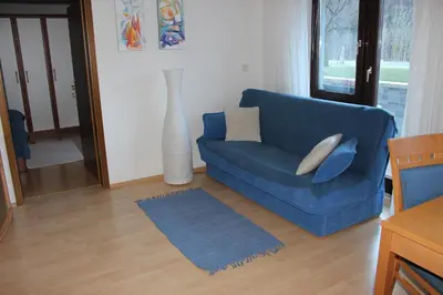 a blue couch with pillows in a living room at Apartma Maržič in Kranjska Gora