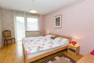 a bedroom with a bed and a chair in it at Apartment Ina in Bled