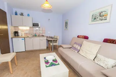 a living room with a couch and a kitchen at Apartment Ina in Bled