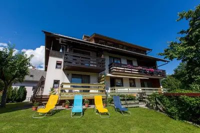 a group of chairs in front of a house at Apartment Ina in Bled