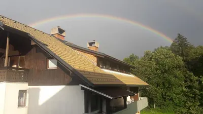 a rainbow in the sky above a house at Apartment Ina in Bled