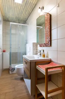 a bathroom with a sink and a toilet and a mirror at Apartment Ina in Bled