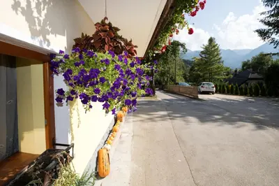 a building with flowers on the side of a street at Farmhouse pri Miklavu in Bohinj