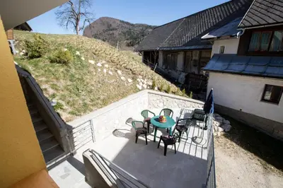 a patio with a table and chairs on a balcony at Farmhouse pri Miklavu in Bohinj