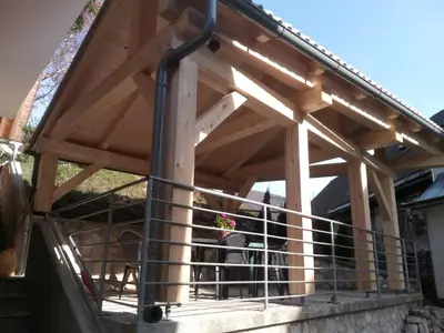 a wooden deck with a metal railing on a house at Farmhouse pri Miklavu in Bohinj