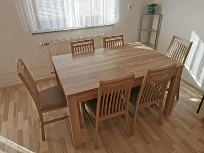 a dining room table with chairs and a wooden table at Apartments Henigman in Bohinj