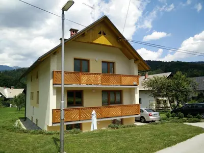 a house with a balcony on the side of it at Apartments Henigman in Bohinj