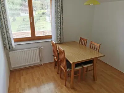 a dining room with a wooden table and chairs at Apartments Henigman in Bohinj