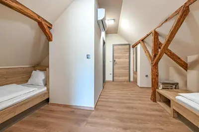 a bedroom with two beds and wooden floors at Turistična Kmetija Pungračič in Zavrč