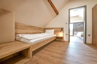 a bedroom with a bed on a wooden bench at Turistična Kmetija Pungračič in Zavrč