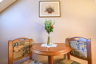 a table and two chairs with a vase of flowers at Turistična Kmetija Pungračič in Zavrč