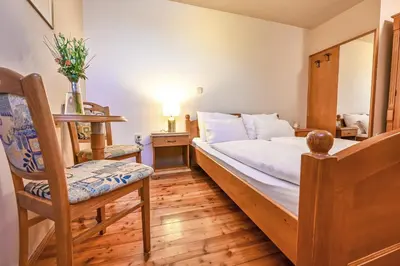 a small bedroom with a bed and a chair at Turistična Kmetija Pungračič in Zavrč