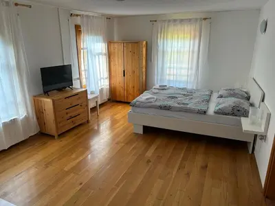 a bedroom with a bed and a flat screen tv at Stres-less Sunny Apartments in Kobarid