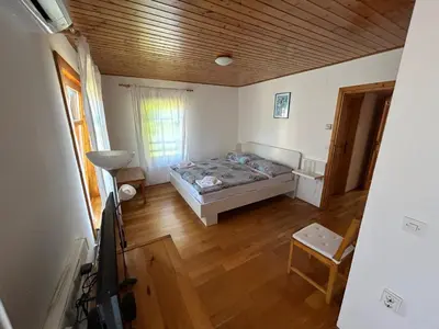 a bedroom with a bed and a wooden ceiling at Stres-less Sunny Apartments in Kobarid