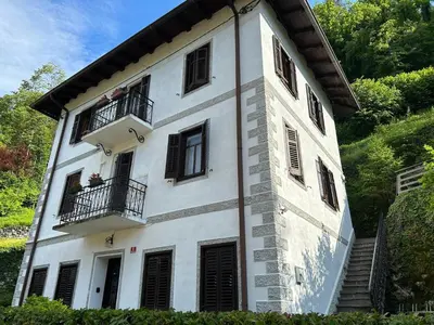 a white building with black windows and a balcony at Stres-less Sunny Apartments in Kobarid
