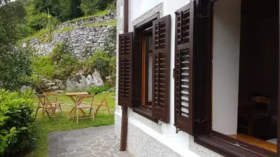 an open window of a house with a table and chairs at Stres-less Sunny Apartments in Kobarid