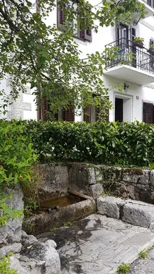 a building with a pond in front of a house at Stres-less Sunny Apartments in Kobarid