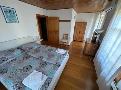 a bedroom with a bed and a wooden floor at Stres-less Sunny Apartments in Kobarid