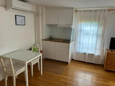 a kitchen with a white table and a table and a chair at Stres-less Sunny Apartments in Kobarid
