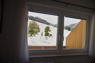 a window with a view of a snow covered yard at Apartment Katarina Kranjska Gora in Kranjska Gora