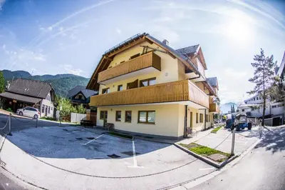 a large yellow building on the side of a street at Apartment Katarina Kranjska Gora in Kranjska Gora
