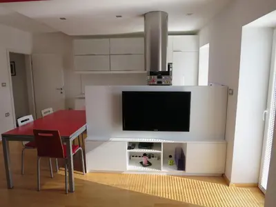 a living room with a table and a tv on a wall at TIN House in Povir