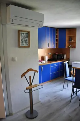 a kitchen with blue cabinets and a table and chairs at Simpli Apartments in Ljubljana