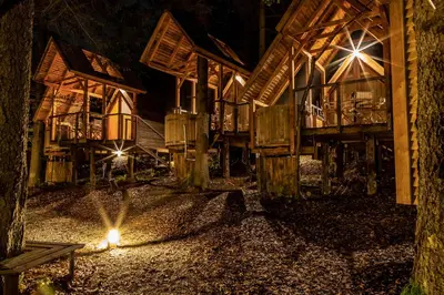 a night view of a building with lights on the street at Ribno Alpine Glamping in Bled