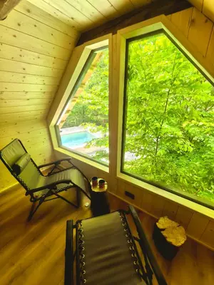 a room with a chair and a window in a cabin at Ribno Alpine Glamping in Bled