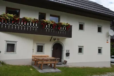 a building with a balcony and a wooden bench at Apartment Zatrnik in Bled