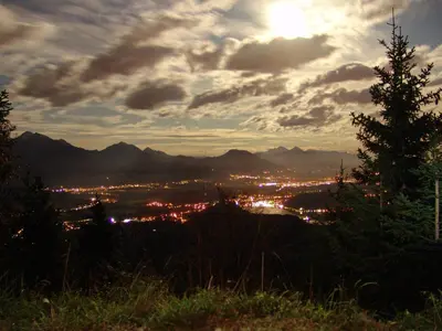 a view of a city from a hill with the sunset at Apartment Zatrnik in Bled