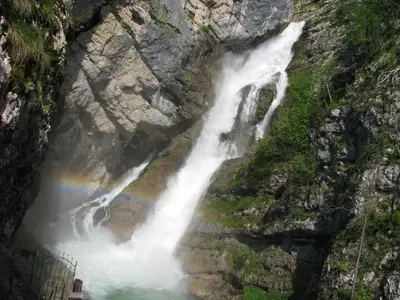 a rainbow in front of a waterfall on a cliff at Apartment Zatrnik in Bled