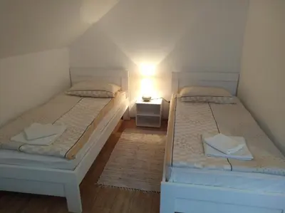 two beds in a small room with a lamp at Apartment Sela in Tolmin