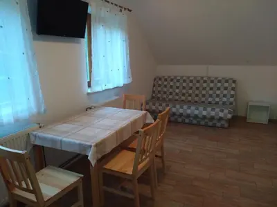 a dining room with a table and chairs and a couch at Apartment Sela in Tolmin