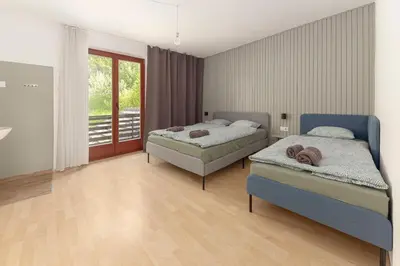 a bedroom with two beds and a balcony at Appleby Apartments Kersnik in Bohinj