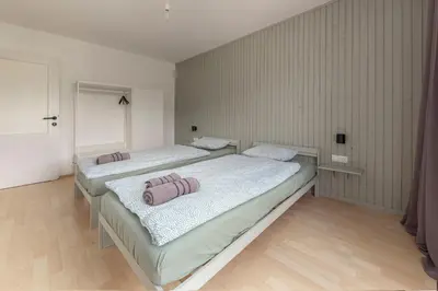 two twin beds in a room with wooden floors at Appleby Apartments Kersnik in Bohinj