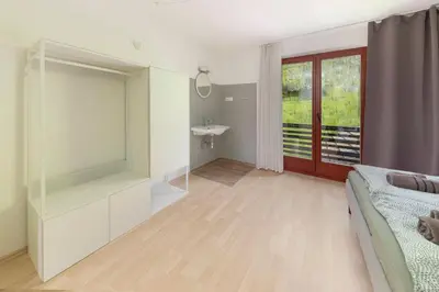 a bedroom with a bed and a bathroom with a sink at Appleby Apartments Kersnik in Bohinj