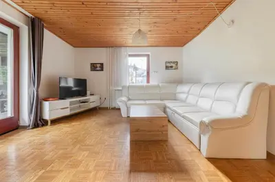 a living room with a white couch and a tv at Appleby Apartments Kersnik in Bohinj