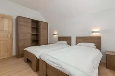 two beds in a bedroom with white sheets at Appleby Apartments Kersnik in Bohinj