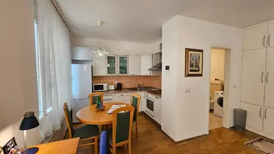a kitchen with a table and a dining room at Central Apartment Anita Tour As Ljubljana in Ljubljana