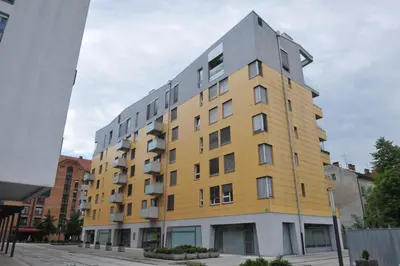 a yellow and gray building on a city street at Central Apartment Anita Tour As Ljubljana in Ljubljana