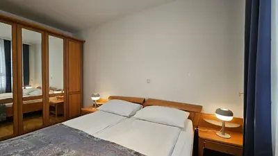 a bedroom with a bed and two lamps and a mirror at Central Apartment Anita Tour As Ljubljana in Ljubljana