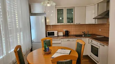 a kitchen with a wooden table and a refrigerator at Central Apartment Anita Tour As Ljubljana in Ljubljana