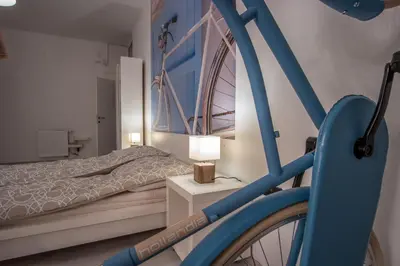 a bedroom with a blue bike parked next to a bed at Bicycle apartment Ljubljana in Ljubljana